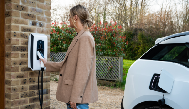 Woman charging her electric vehicle